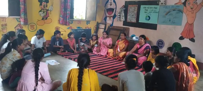 Empowering women and children through education. A group of women and children engaged in a discussion inside a classroom